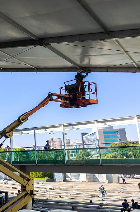 Técnico em plataforma elevatória trabalhando em uma cobertura