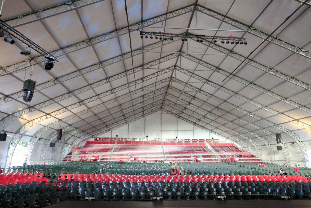 Interior de cobertura NFS com arquibancada e grid de iluminação de palco